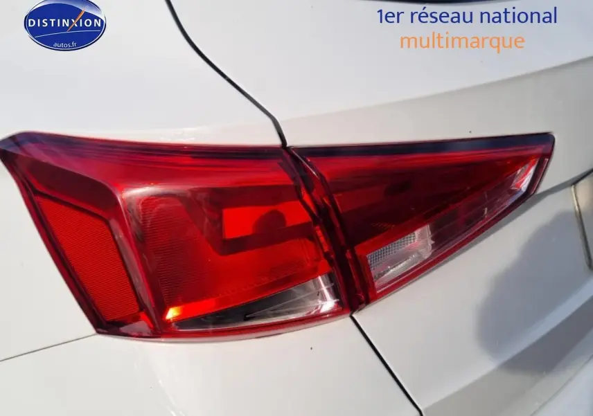 Gros plan sur le feu arrière droit rouge d’un SEAT Arona blanc, avec partie de la carrosserie visible.