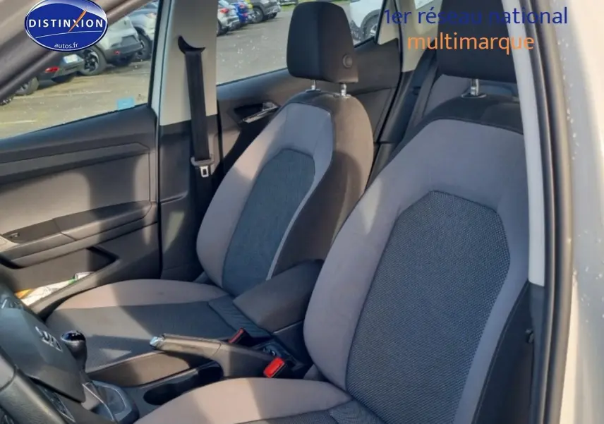 Vue intérieure côté conducteur du siège avant gris et noir d'une SEAT Arona 1.6 TDI 2019 avec levier de vitesse manuel en cuir.