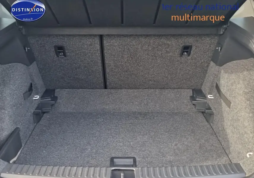 Coffre ouvert d'une SEAT Arona blanc 2019, vue intérieure montrant l'espace de chargement et la moquette grise.