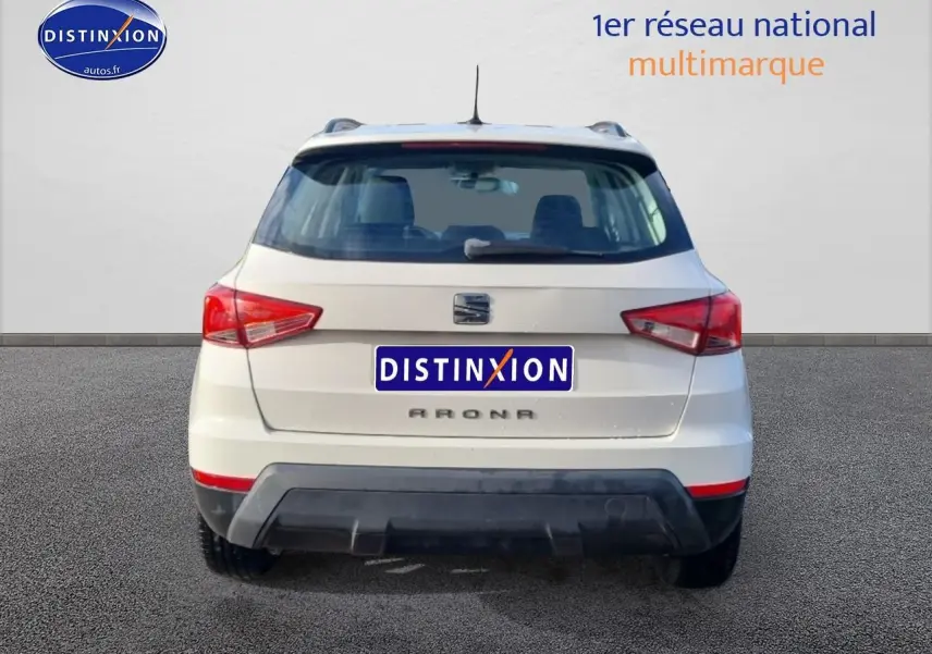 Vue arrière d'un SEAT Arona blanc de 2019 avec feux arrière LED et barres de toit visibles.