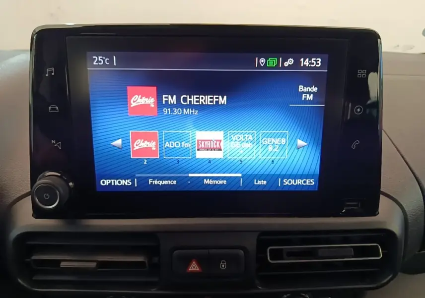 Écran tactile central du Toyota Proace City Verso électrique 2022 affichant les stations radio FM, entouré de commandes et aérateurs noirs.