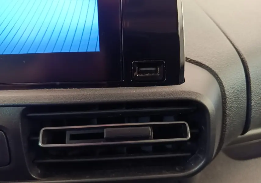 Gros plan sur la prise USB et la sortie d'aération du tableau de bord du Toyota Proace City Verso électrique gris clair.