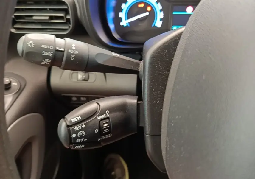Gros plan sur la commande de régulateur de vitesse et éclairage du tableau de bord bleu du Toyota Proace City Verso électrique 2022.