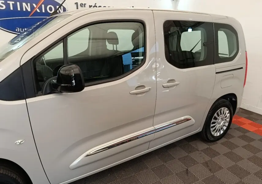 Vue latérale droite d'un Toyota Proace City Verso électrique gris clair avec jantes argentées et vitres teintées.