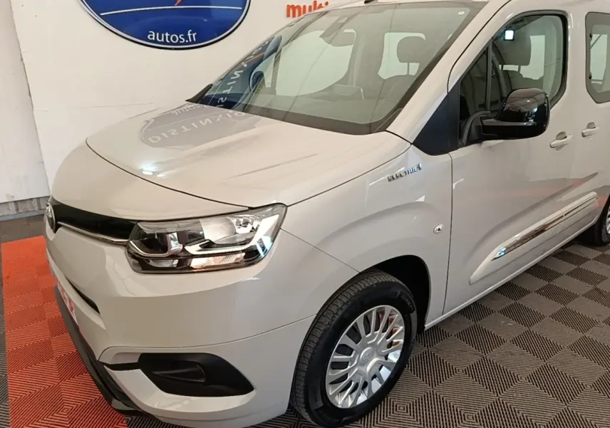 Vue 3/4 avant droit du Toyota Proace City Verso électrique gris clair, avec badge "Electric" visible sur l'aile avant.