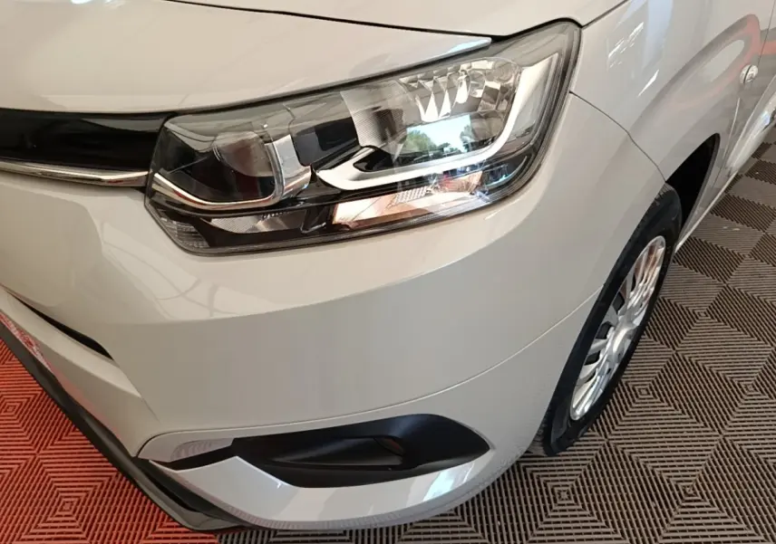 Gros plan sur l'avant droit gris clair du Toyota Proace City Verso Electric 2022, mettant en valeur le phare et la roue.
