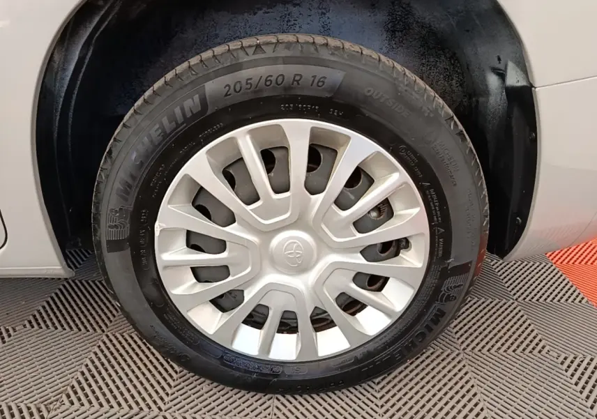 Gros plan sur la roue avant droite d’un Toyota Proace City Verso gris clair avec jante acier et enjoliveur plastique.