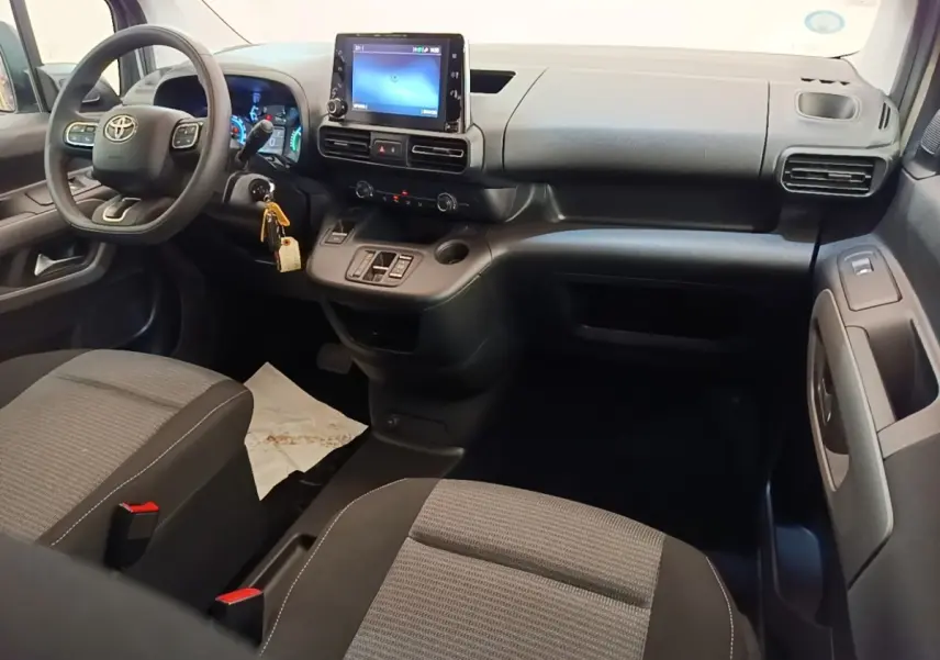 Vue intérieure avant du Toyota Proace City Verso électrique 2022, tableau de bord avec écran tactile et sièges gris.