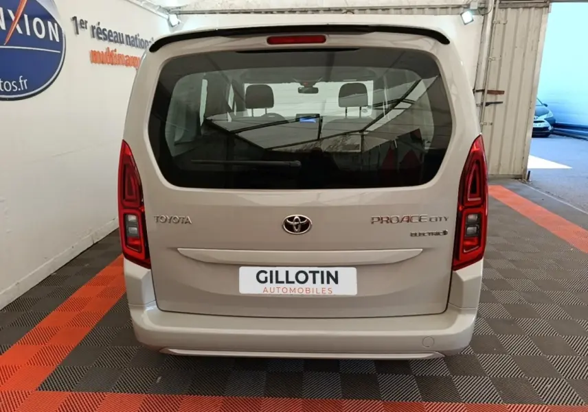 Vue arrière d’un Toyota Proace City Verso gris clair électrique, avec feux arrière rouges et vitre arrière large.