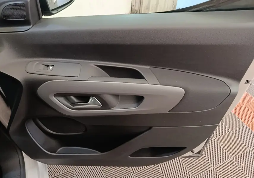 Détail de la porte intérieure côté conducteur du Toyota Proace City Verso électrique 2022, avec poignée grise et commande de fenêtre.
