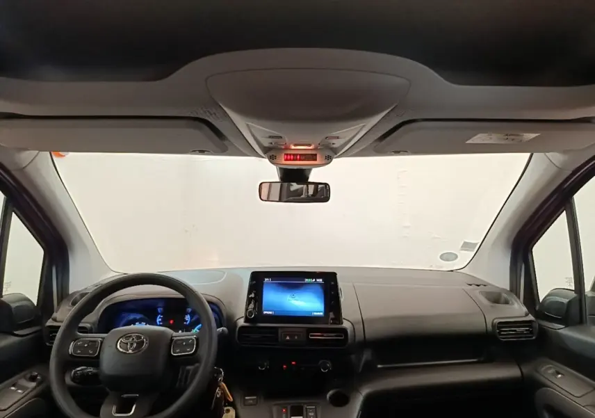 Vue intérieure frontale du tableau de bord gris foncé et volant multifonctions du Toyota Proace City Verso électrique 2022.