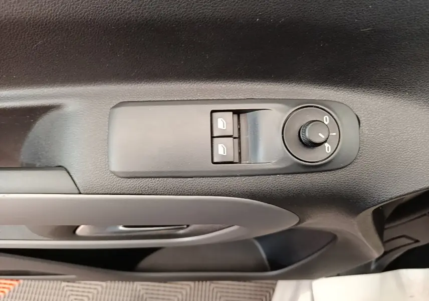 Gros plan sur les commandes de réglage des rétroviseurs et vitres sur la porte intérieure côté conducteur du Toyota Proace City Verso gris.