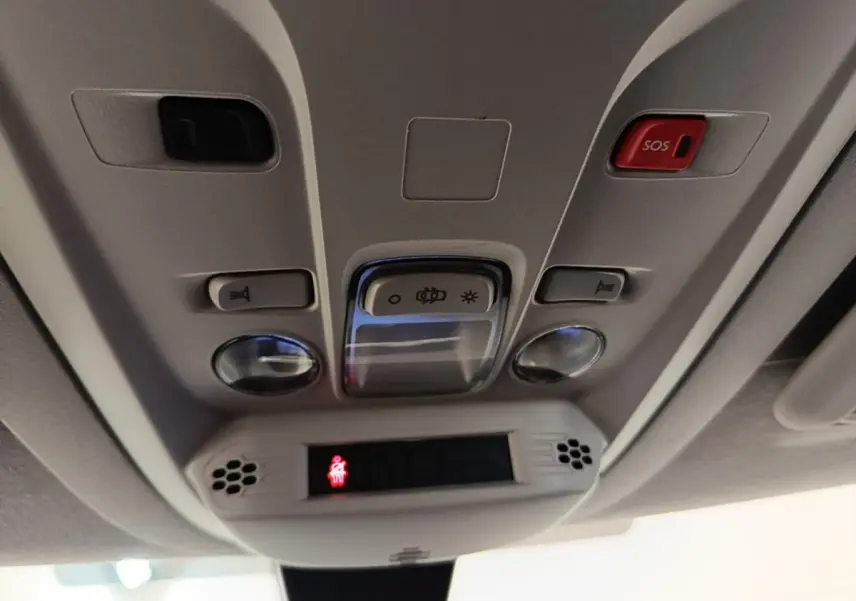 Vue en gros plan du panneau de commande de toit intérieur gris clair du Toyota Proace City Verso électrique avec bouton SOS rouge.