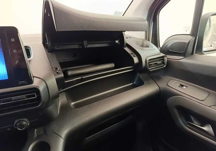 Vue intérieure côté passager du Toyota Proace City Verso électrique 2022, montrant la boîte à gants ouverte et la console noire.