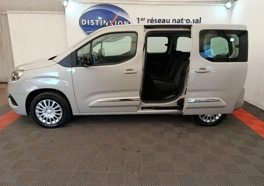 Vue latérale droite d'un Toyota Proace City Verso électrique gris clair avec porte coulissante arrière ouverte.