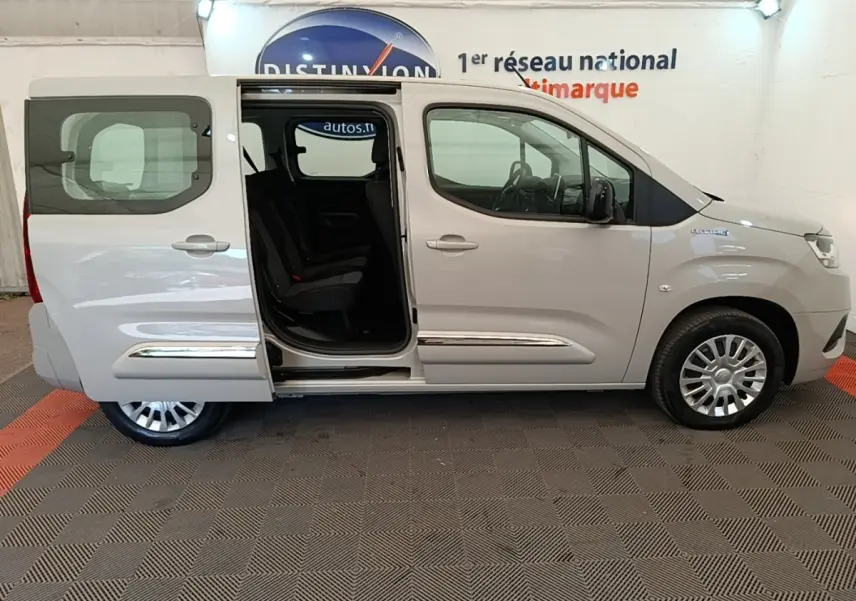 Vue de profil côté droit d'un Toyota Proace City Verso électrique gris clair avec porte coulissante arrière ouverte.