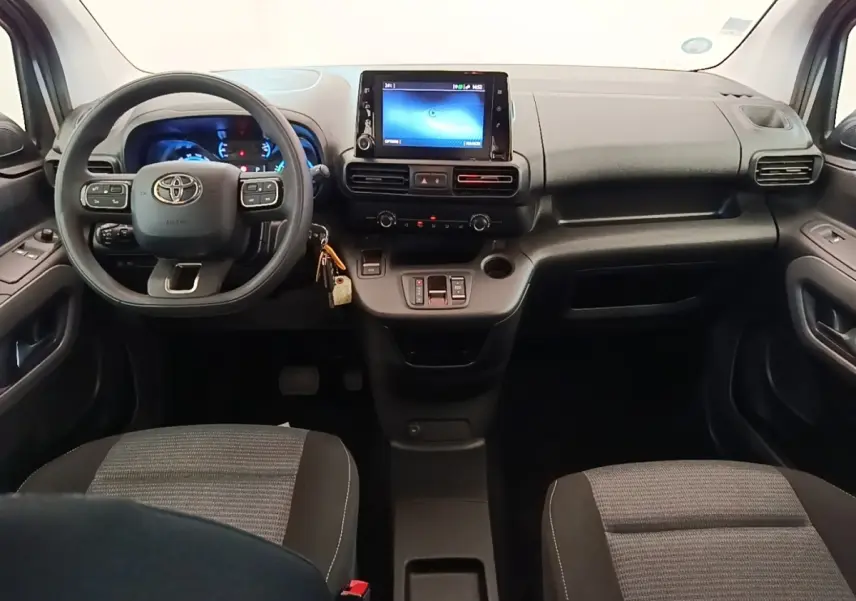 Vue intérieure avant du Toyota Proace City Verso électrique 2022, tableau de bord noir avec écran tactile central.