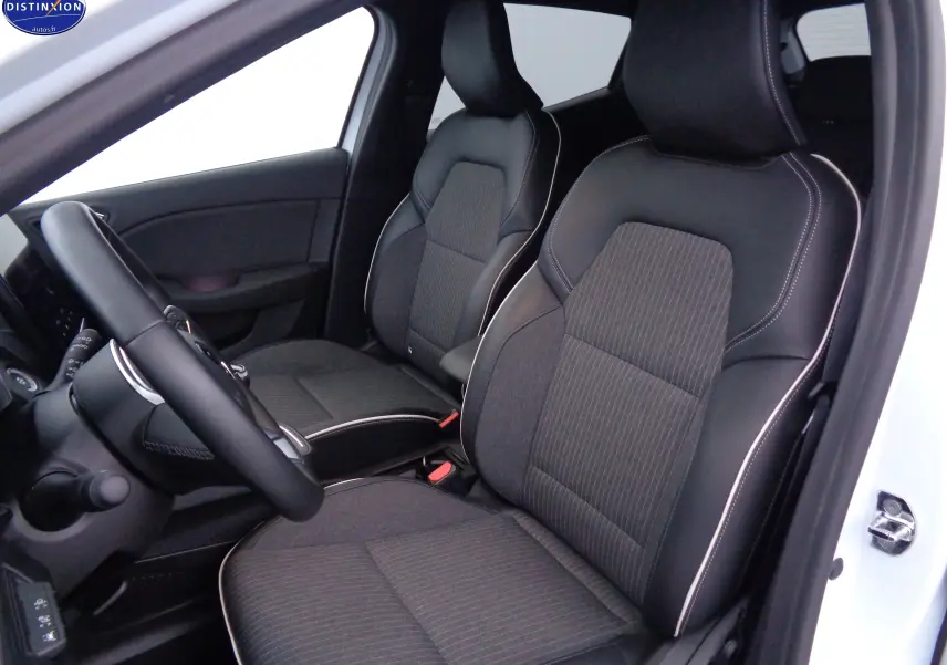 Vue intérieure côté conducteur de la Renault Clio V blanc nacré métal, sièges tissu et cuir noir avec surpiqûres blanches.