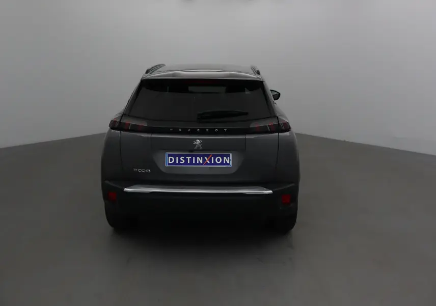 Vue arrière d'un Peugeot 2008 gris platinium 2022 avec feux arrière noirs et logo distinctif au centre.