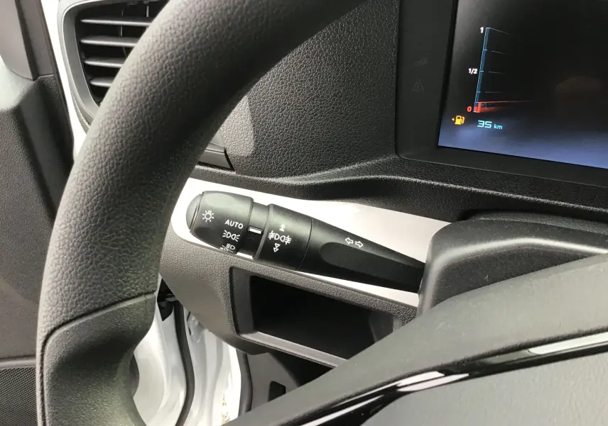 Gros plan sur la manette de clignotant et phares à gauche du volant dans l'habitacle blanc du Citroën Jumpy Cabine Approfondie.