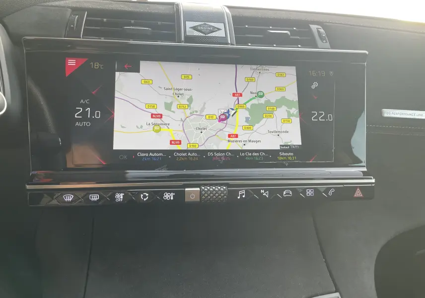 Vue rapprochée de l'écran tactile central du DS7 gris 2021, affichant la navigation GPS et les commandes climatiques digitales.