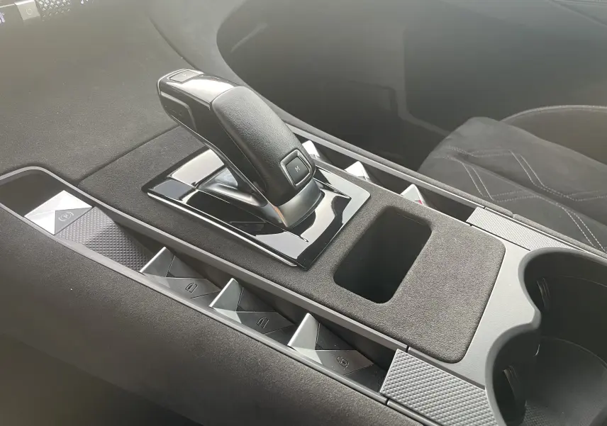 Le levier de vitesse noir et brillant de la DS7 1.5 BlueHDi 130 en vue rapprochée sur la console centrale grise.
