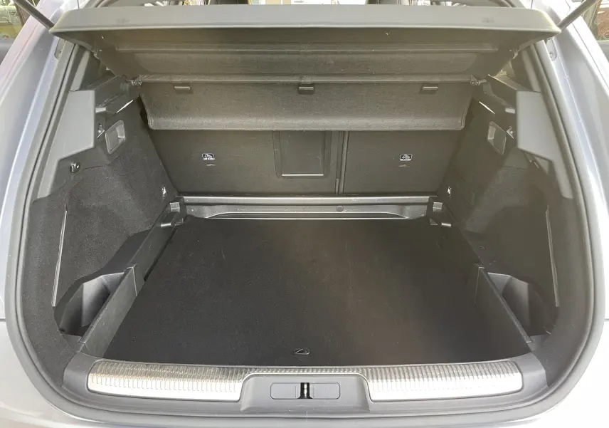 Coffre ouvert du DS7 gris, vue de l'arrière montrant un espace de chargement propre et bien agencé.
