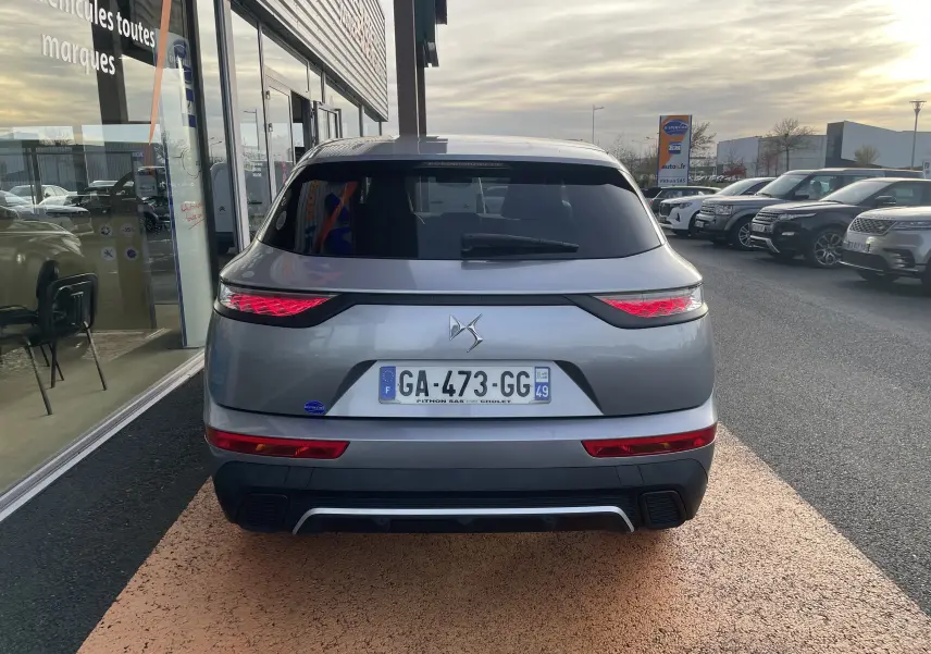 Vue arrière d'un DS7 gris avec feux LED distinctifs et plaque d'immatriculation française visible.