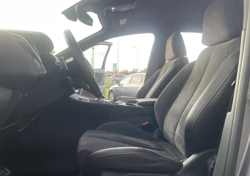 Intérieur du DS7 2021 en gris noir, vue côté conducteur sur les sièges avant et le volant multifonction.