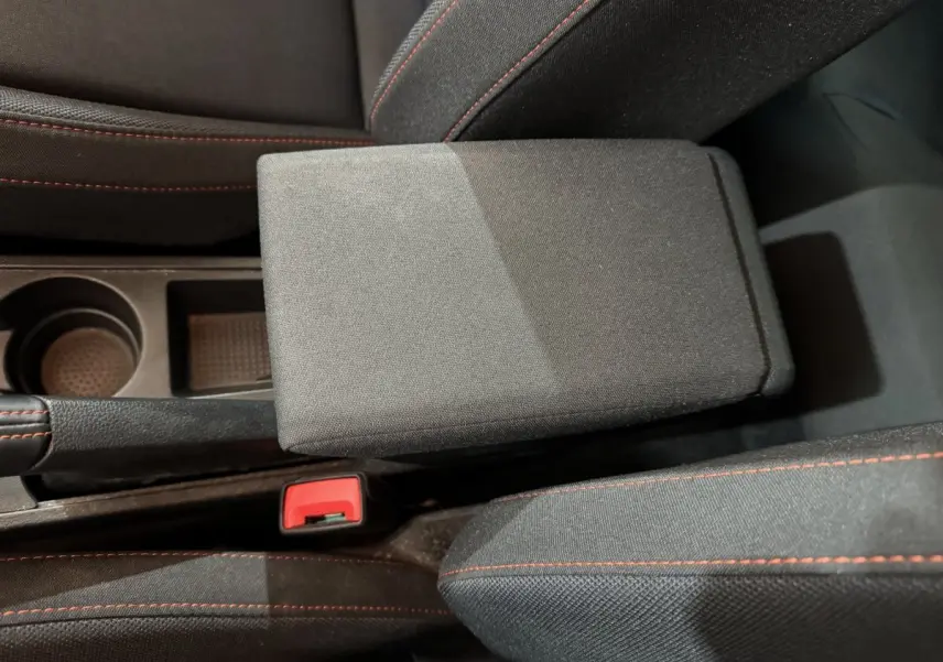 Gros plan sur l'accoudoir central et la console noire avec surpiqûres rouges dans l'habitacle d'une SEAT Ibiza 2024.