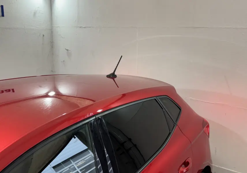 Vue rapprochée du toit et du côté gauche arrière d'une SEAT Ibiza rouge avec vitres teintées et antenne courte.