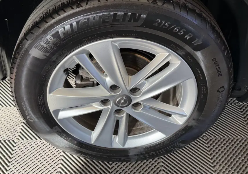 Gros plan sur la roue avant droite avec jante argentée et pneu Michelin du Opel Grandland X noir.
