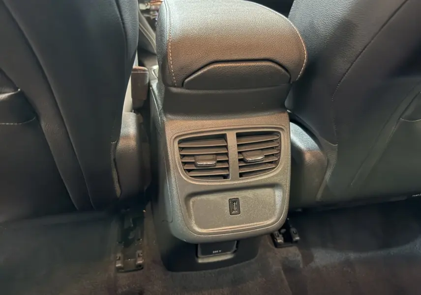 Vue rapprochée des aérateurs arrière et prise USB entre les sièges avant noirs de l'Opel Grandland X noir.