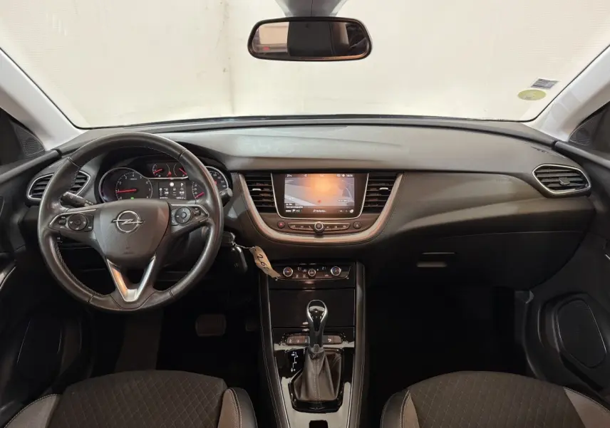 Vue intérieure avant de l’Opel Grandland X 2021, tableau de bord noir avec écran tactile et volant cuir multifonctions.