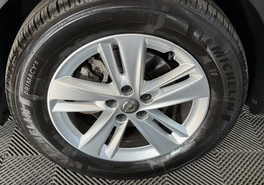Gros plan sur la jante argentée à cinq branches du pneu Michelin d’un Opel Grandland X noir.