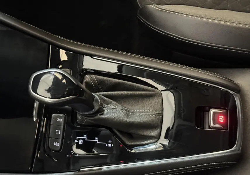 Gros plan sur la console centrale noire de l’Opel Grandland X 1.5 Diesel 130 Elegance Business Auto avec levier de vitesse automatique.