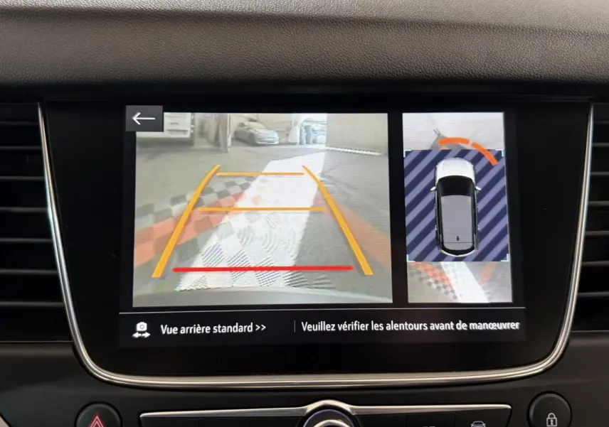 Écran tactile intérieur montrant la caméra de recul et l’aide au stationnement du tableau de bord Opel Grandland X noir.