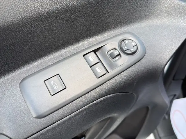 Gros plan sur les commandes de lève-vitres et rétroviseurs côté conducteur du Citroën Berlingo blanc 2025.