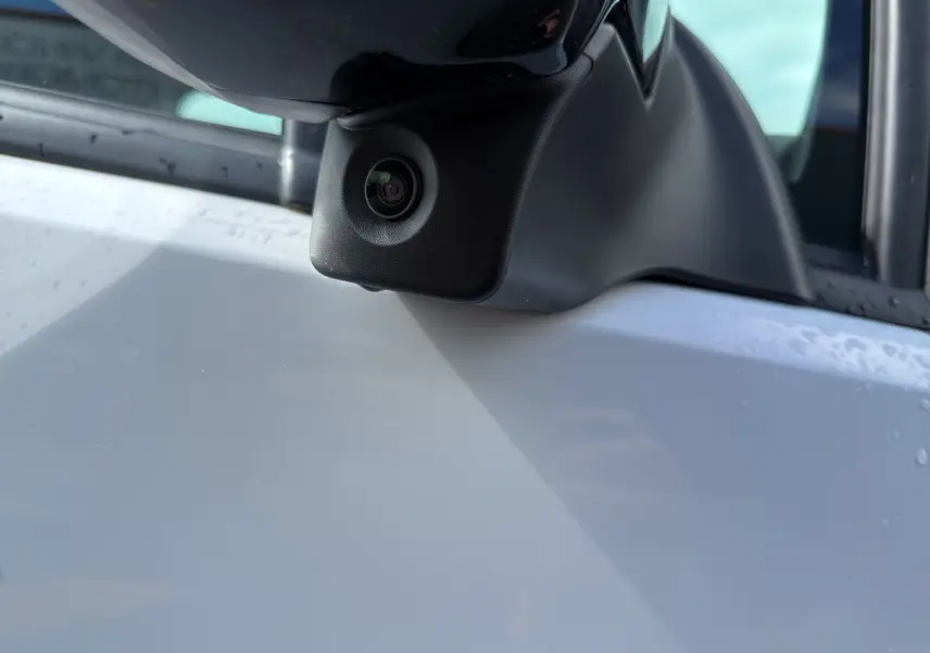 Gros plan sur la caméra intégrée au rétroviseur côté conducteur du Citroën Berlingo blanc 2025.