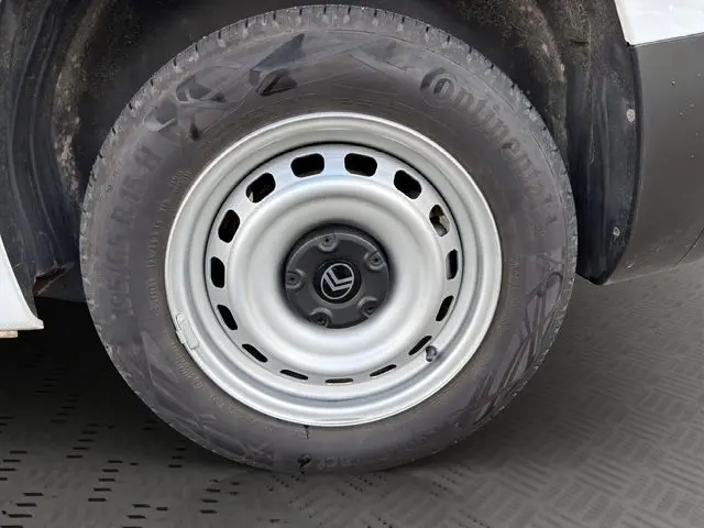 Gros plan sur la roue avant gauche du Citroën Berlingo blanc 2025, jante acier avec logo Citroën au centre.