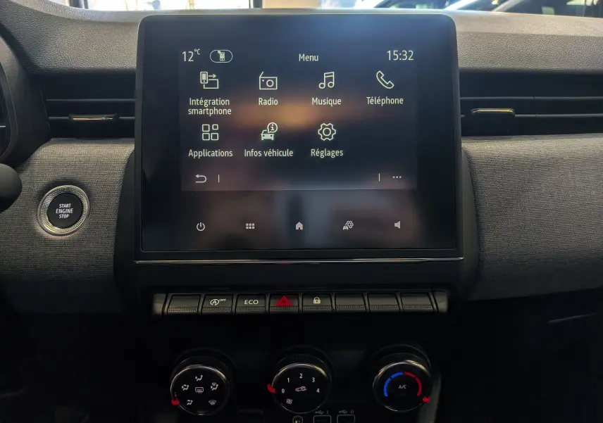 Vue rapprochée de l’écran tactile central et des commandes de climatisation de la Renault Clio V Bleu Iron, intérieur tissu noir.