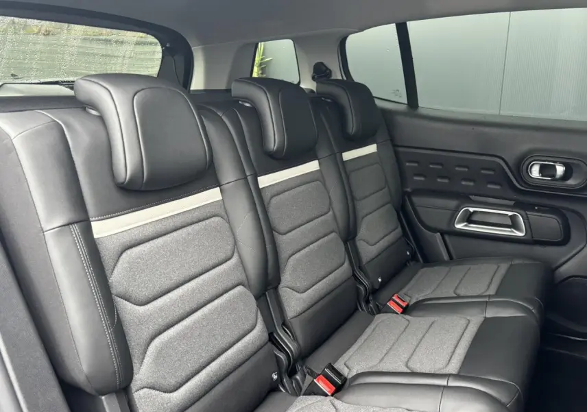 Vue latérale intérieure des trois sièges arrière indépendants en cuir et tissu gris du Citroën C5 Aircross 2025.