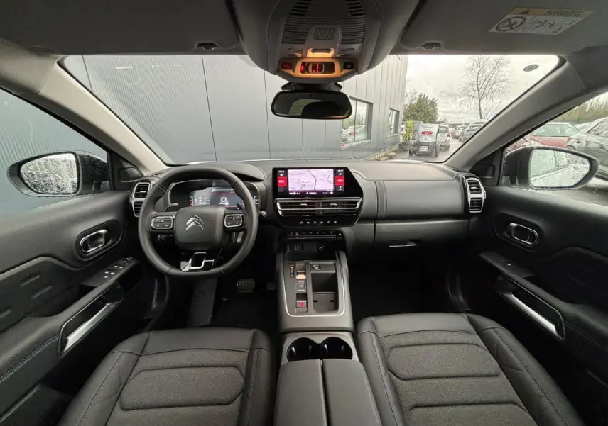 Vue intérieure avant du Citroën C5 Aircross 2025, tableau de bord noir avec écran tactile et volant multifonction.