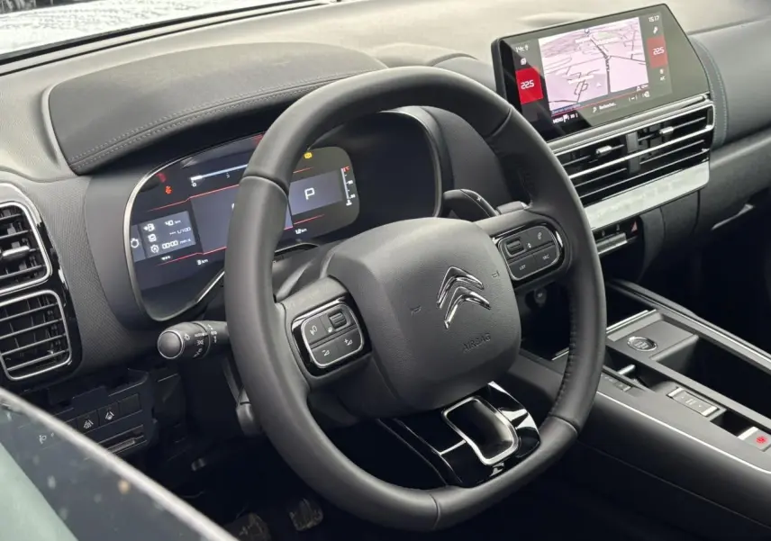 Vue rapprochée du volant et du tableau de bord numérique du Citroën C5 Aircross blanc, avec écran tactile et commandes intégrées.