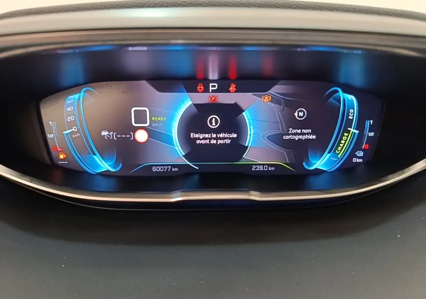 Vue rapprochée du tableau de bord numérique bleu du Peugeot 3008 Hybrid 225 GT affichant 60 077 km et messages d'alerte.