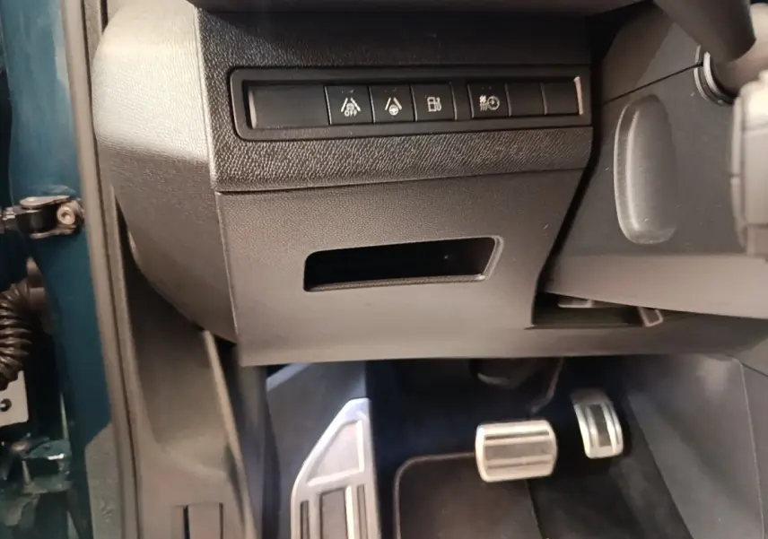Vue intérieure côté conducteur du Peugeot 3008 bleu, montrant les pédales sport en aluminium et les commandes sous le tableau de bord.
