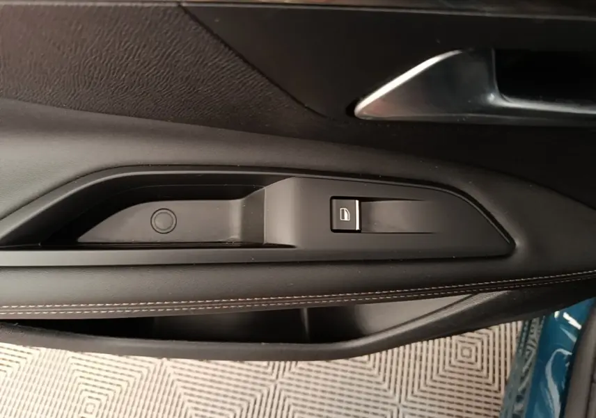 Détail de la commande de lève-vitre côté gauche sur porte intérieure noire du Peugeot 3008 bleu 2022 hybride rechargeable.