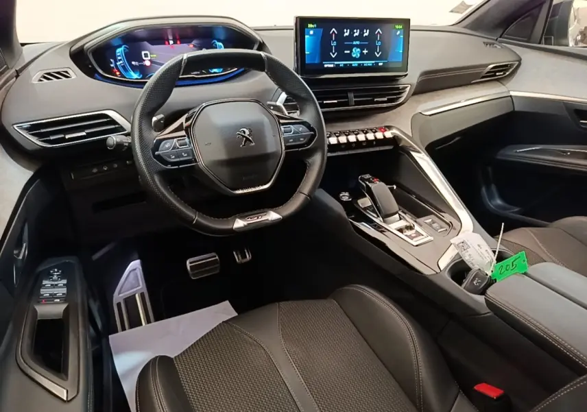 Intérieur du Peugeot 3008 hybride 2022 vu côté conducteur, volant cuir, tableau de bord digital et console centrale moderne.