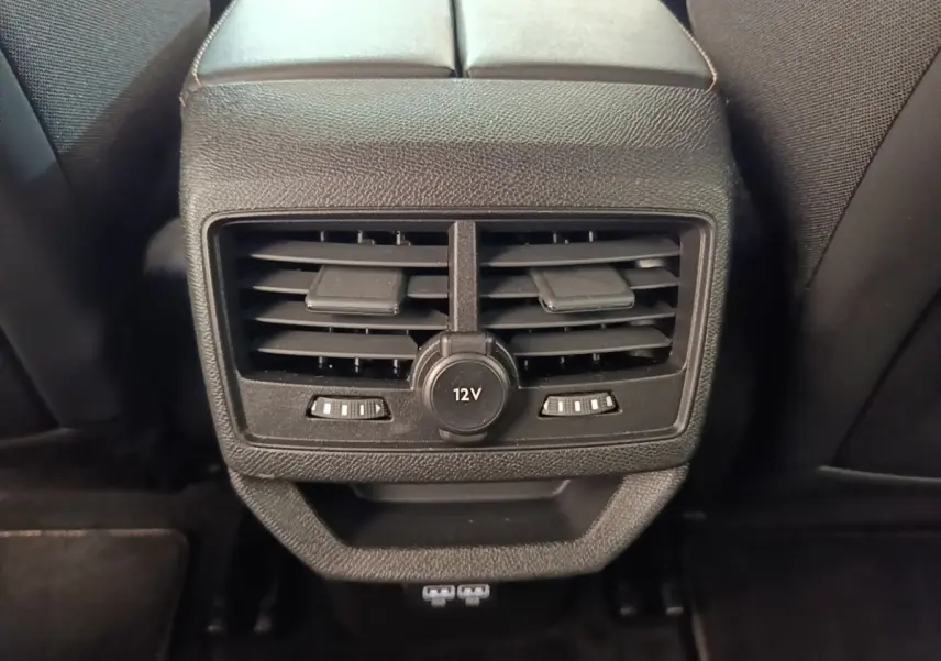 Vue rapprochée des aérateurs arrière noirs et prise 12V du Peugeot 3008 hybride rechargeable bleu 2022.