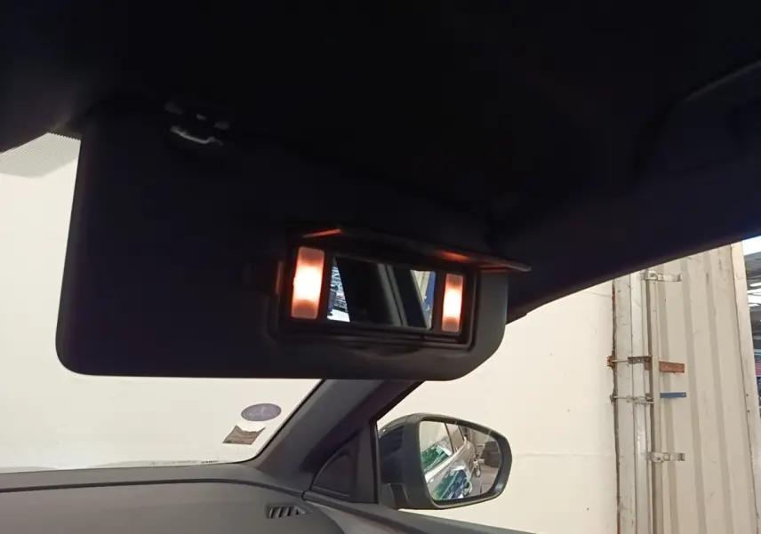 Vue intérieure côté gauche du Peugeot 3008 bleu, avec miroir de courtoisie éclairé sur pare-soleil.